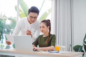 Due giovane attività commerciale colleghi Lavorando con il computer portatile a ufficio foto