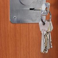 mazzo di chiavi nel buco della serratura di porta vicino su foto