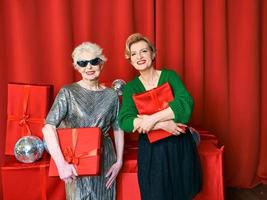 elegante e fantasia anziano e maturo donna a il festa con regalo scatole. festa, celebrazione, tecnologia concetto foto