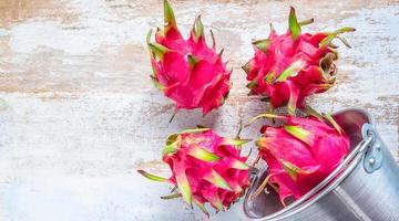 rosso Drago frutta di il genere Hylocereus appartiene per il famiglia cactacee, quale è il stesso famiglia come cactus su di legno sfondo foto