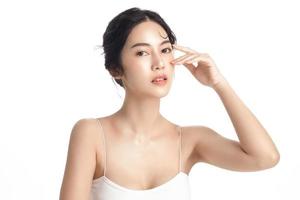 asiatico donna con un' bellissimo viso e Perfetto pulito fresco pelle. carino femmina modello con naturale trucco e scintillante occhi su bianca isolato sfondo. facciale trattamento, cosmetologia, bellezza concetto. foto