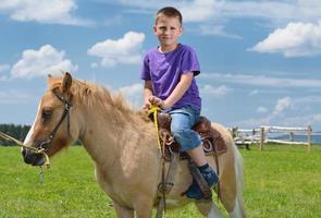 bambino cavalcata pony foto