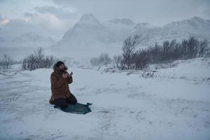 viaggiatore musulmano che prega in una fredda giornata invernale nevosa foto