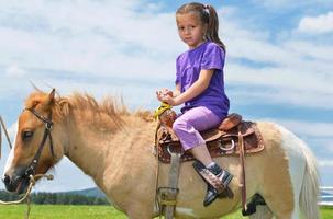bambino cavalcata pony foto