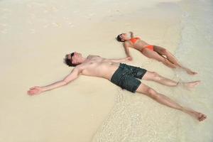 la giovane coppia felice si diverte sulla spiaggia foto