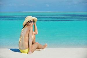 asiatico donna riposo su sabbia a spiaggia foto