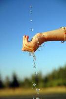 fresco acqua caduta su bambini mani foto