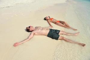 la giovane coppia felice si diverte sulla spiaggia foto