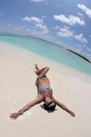 bellissimo giovane donna su spiaggia avere divertimento e rilassare foto