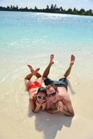 la giovane coppia felice si diverte sulla spiaggia foto