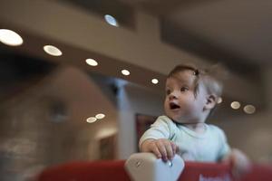 carino poco bambino giocando nel mobile letto foto