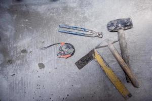 impostato di mano Lavorando utensili su calcestruzzo sfondo foto