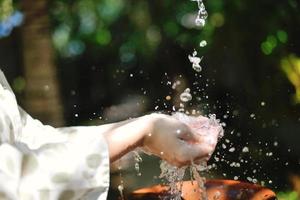 spruzzi fresco acqua su donna mani foto