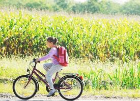 scolara in viaggio per scuola su bicicletta foto