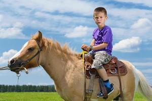 bambino cavalcata pony foto