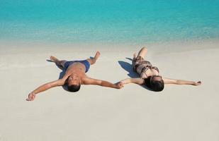 contento giovane coppia godendo estate su spiaggia foto