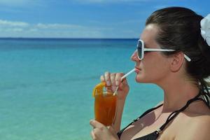 bellissimo giovane donna con un' bevanda di il mare foto