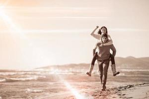 coppia avendo divertimento a spiaggia durante autunno foto