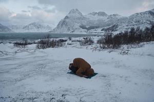 viaggiatore musulmano che prega in una fredda giornata invernale nevosa foto
