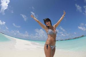 bellissimo giovane donna su spiaggia avere divertimento e rilassare foto