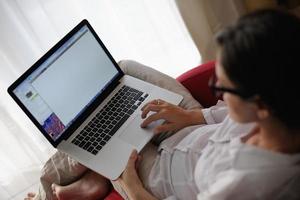 donna utilizzando un' il computer portatile computer a casa foto