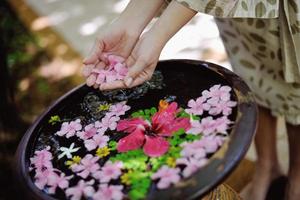 mano femminile e fiore in acqua foto