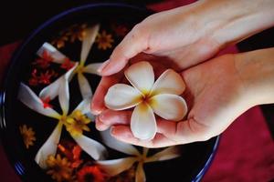 mano femminile e fiore in acqua foto