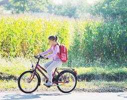 scolara in viaggio per scuola su bicicletta foto