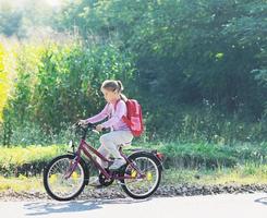 scolara in viaggio per scuola su bicicletta foto