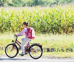 scolara in viaggio per scuola su bicicletta foto