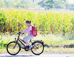 scolara in viaggio per scuola su bicicletta foto