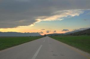 strada di campagna avventura con bellissimo tramonto foto