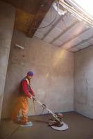lavoratore l'esecuzione e lucidatura sabbia e cemento massetto pavimento foto