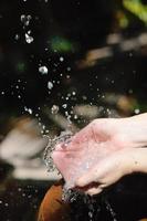 spruzzi fresco acqua su donna mani foto