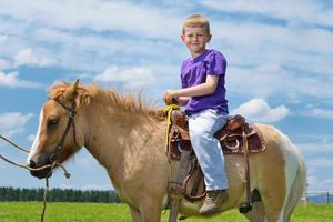 bambino cavalcata pony foto