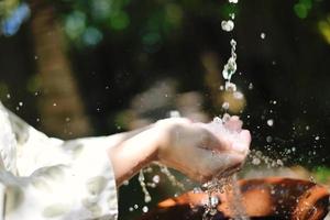 spruzzi fresco acqua su donna mani foto