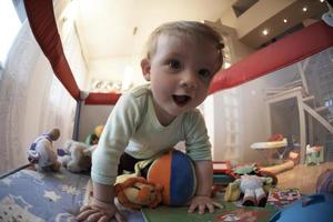 carino poco bambino giocando nel mobile letto foto