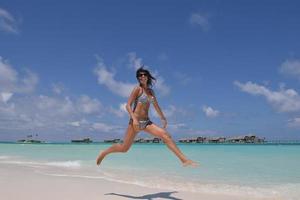 bellissimo giovane donna su spiaggia avere divertimento e rilassare foto