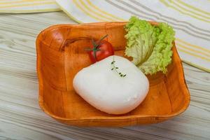 Mozzarella nel un' ciotola su di legno sfondo foto