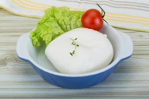 Mozzarella nel un' ciotola su di legno sfondo foto