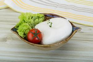 Mozzarella nel un' ciotola su di legno sfondo foto