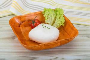 Mozzarella nel un' ciotola su di legno sfondo foto