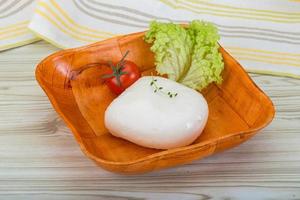 Mozzarella nel un' ciotola su di legno sfondo foto