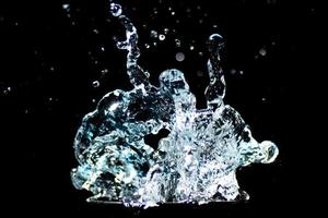 spruzzi acqua su un' nero sfondo. acqua goccioline sparpagliato su un' nero sfondo foto