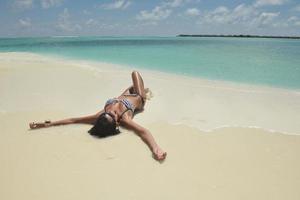 bellissimo giovane donna su spiaggia avere divertimento e rilassare foto