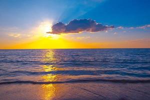 bellissimo tramonto al di sopra di il mare su il tropicale spiaggia con cielo e nuvole per viaggio nel vacanza rilassare tempo foto