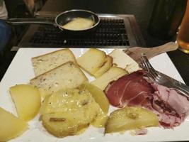 formaggio raclette e prosciutto piatto nel Parigi foto