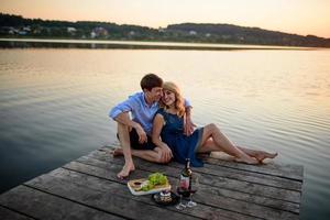 uomo e donna sul molo vicino al lago. foto