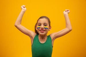 tifoso di calcio, squadra del Brasile. Coppa del Mondo. bella bambina tifo per la sua squadra su sfondo giallo foto