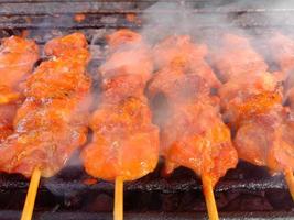 spiedo i pezzi di pollo arrostiti sulla griglia e affumicati. pollo grigliato foto